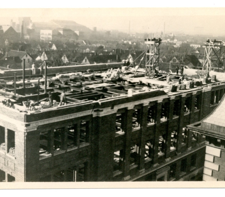 West view of new building nearing completion. View looking west from old building. Old building can be glimpsed on right.