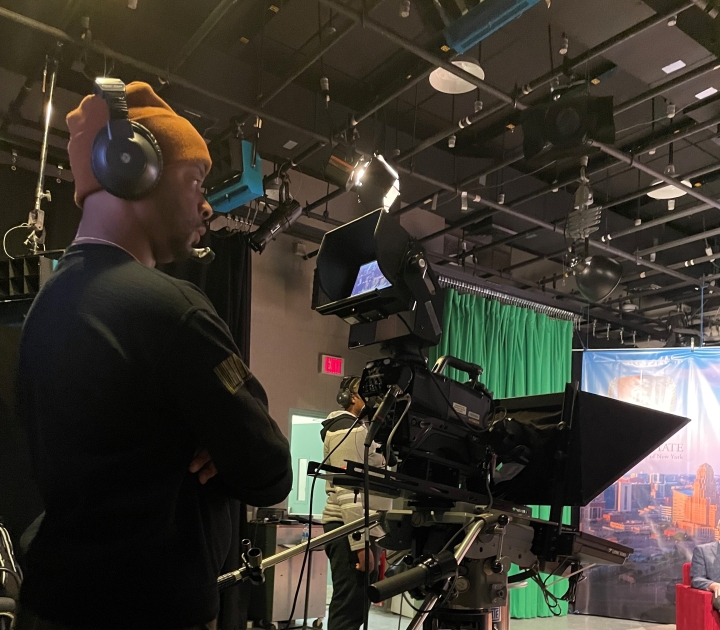 Student behind the camera filming an episode