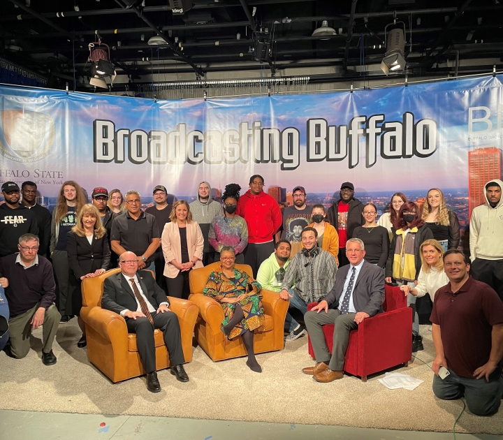 Group photo of students and faculty with President Kate Conway-Turner and Dean Brian Cronk under a banner that reads "Broadcasting Buffalo"