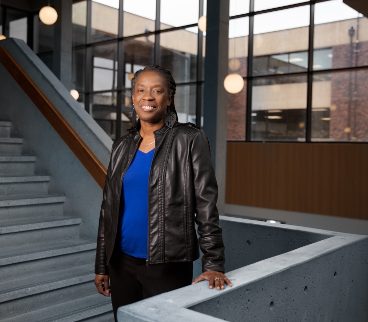 Sheila Rayam stands on the stairway landing in Butler Library