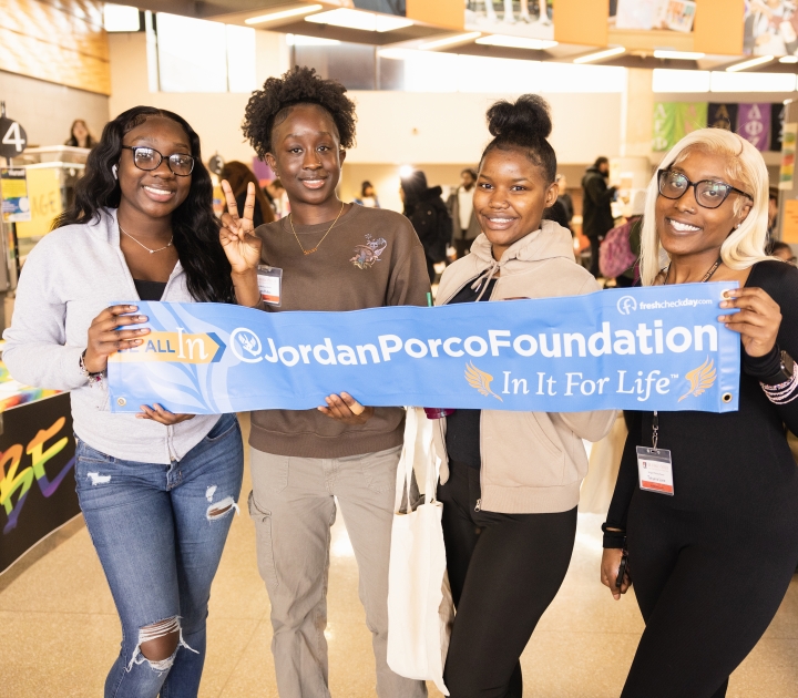 Four students at the Fresh Check event hold a long banner that says Jordan Porco Foundation