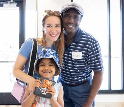Woman, man, and child smile for the camera, displaying a Bengals logo