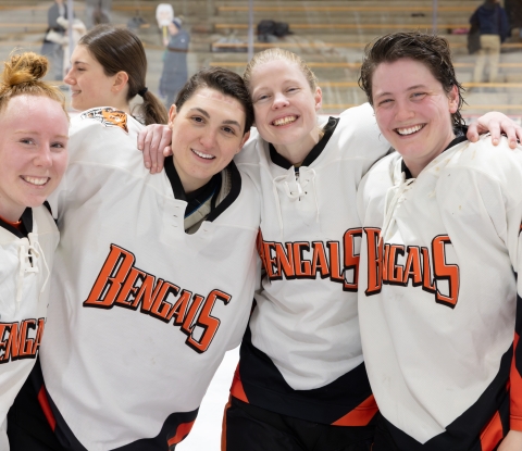 Four female hockey players in Bengals jerseys