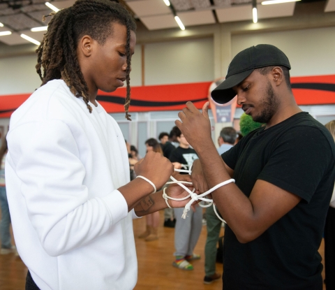 Two male students engaged in a human knot activity