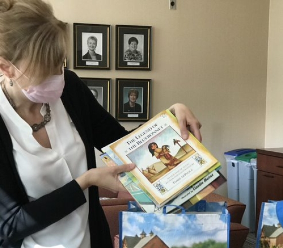 Patricia George loads Wegmans shopping bag with children's books