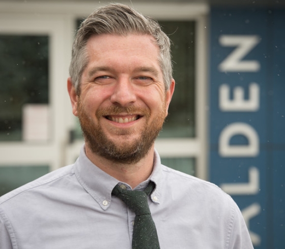 Colin Dabkowski standing in front of Alden banner