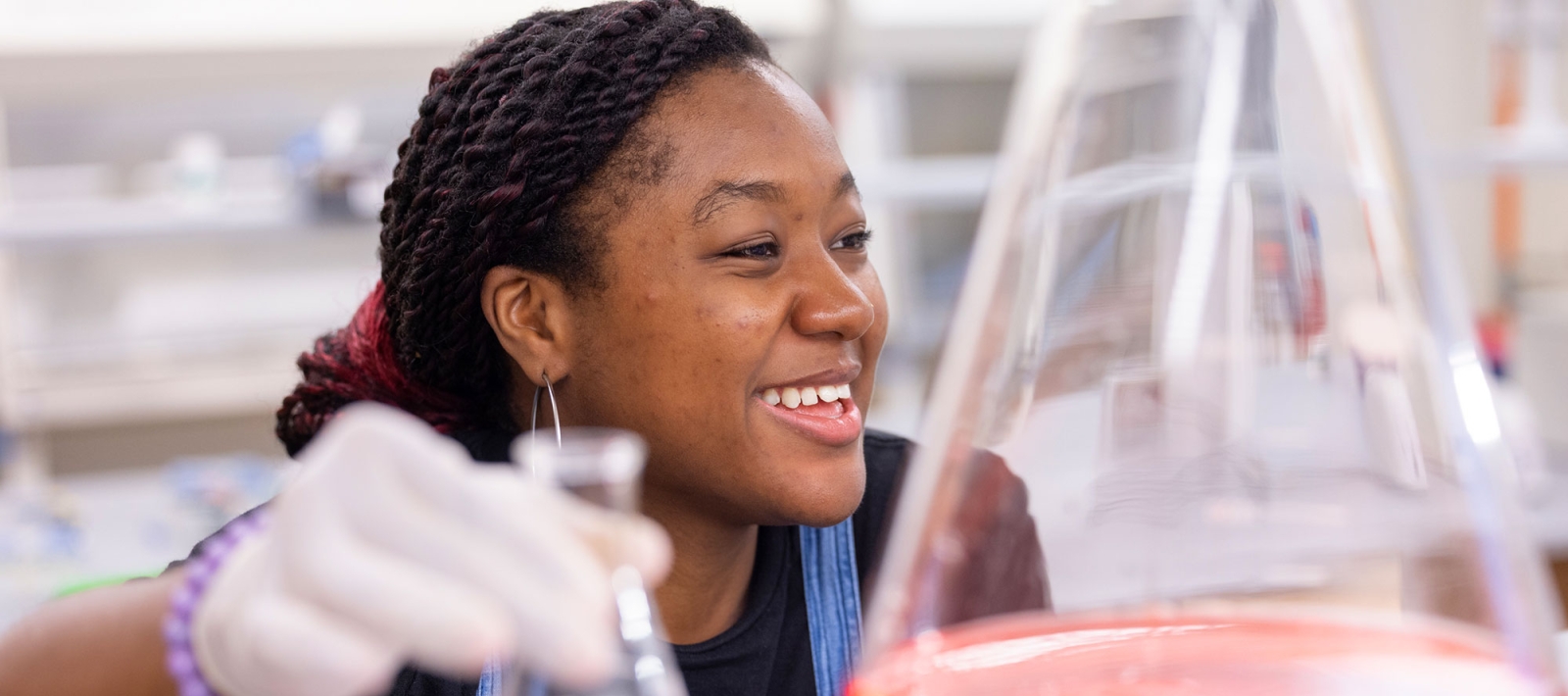 Student in a lab with beakers
