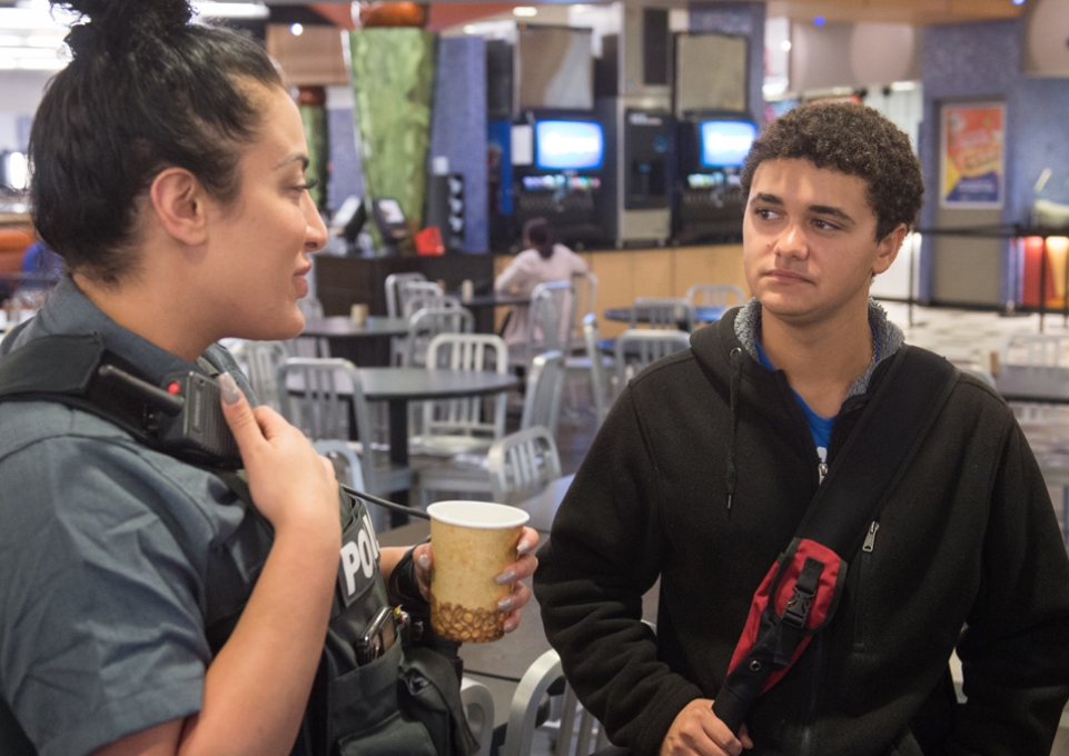 Female police officer talking to male student