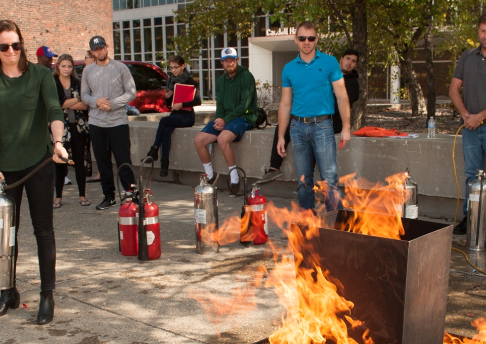 Student practicing with fire extinguisher