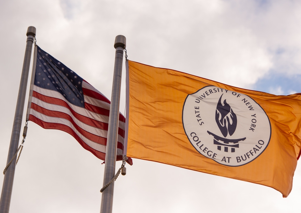 American flag wavign alongside college flag