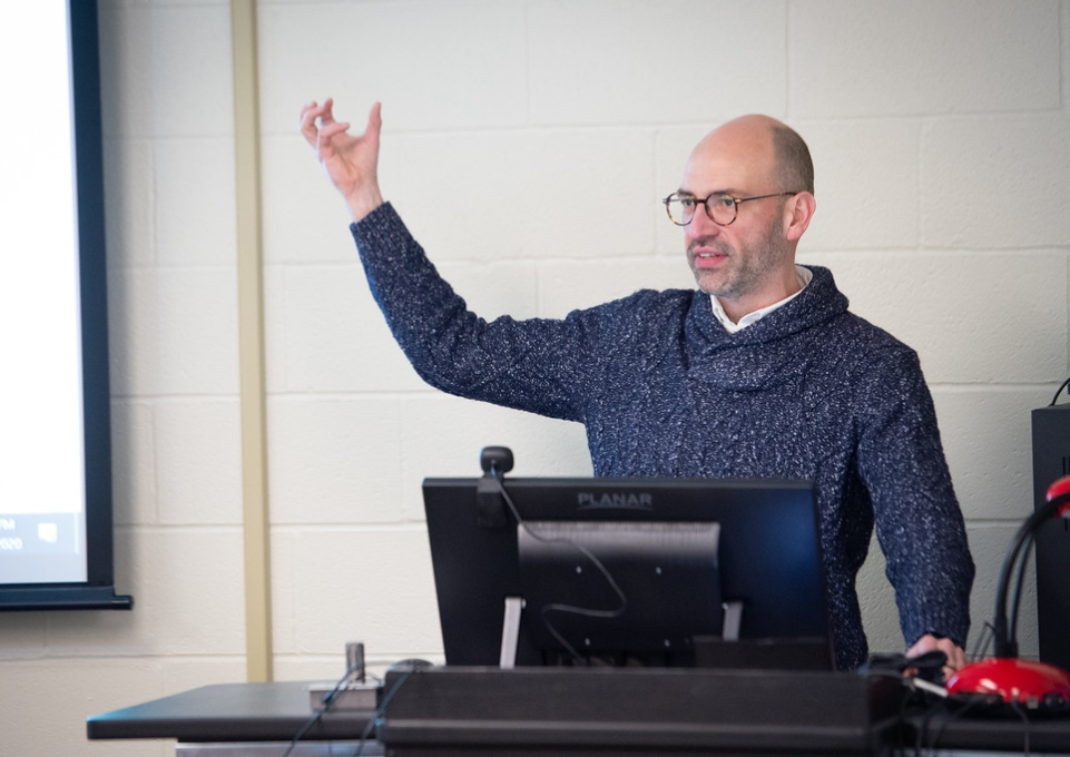 Educational technology specialist Todd Benzin lectures in front of a computer monitor
