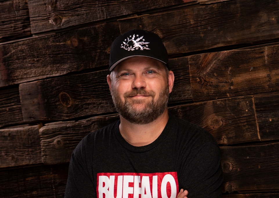 Del Reid standing with arms crossed, wearing shirt that says Buffalo