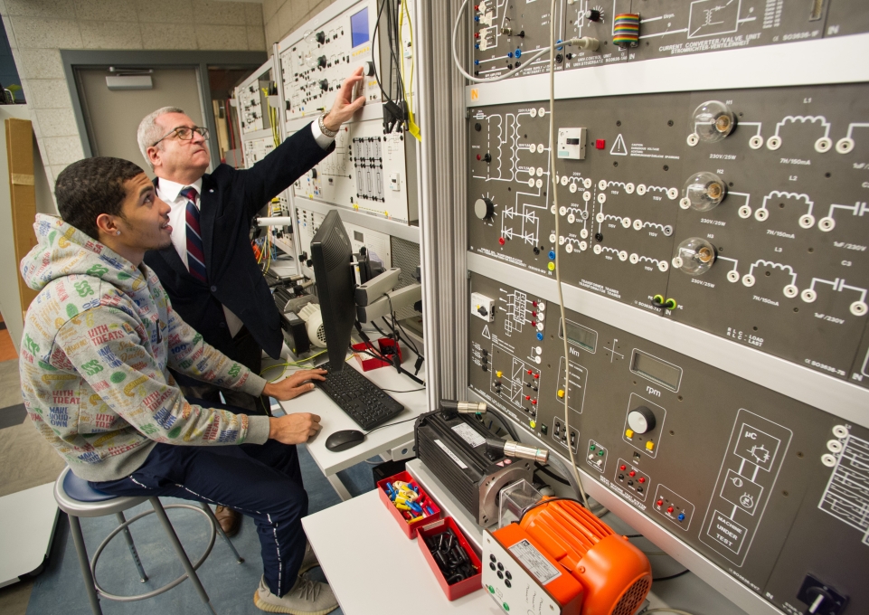 Ilya Grinberg works with a student on the smart grid installation