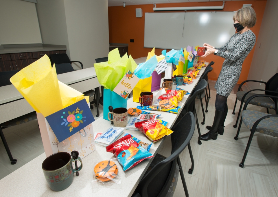 Carol DeNysschen assembles gift bags lined up on table