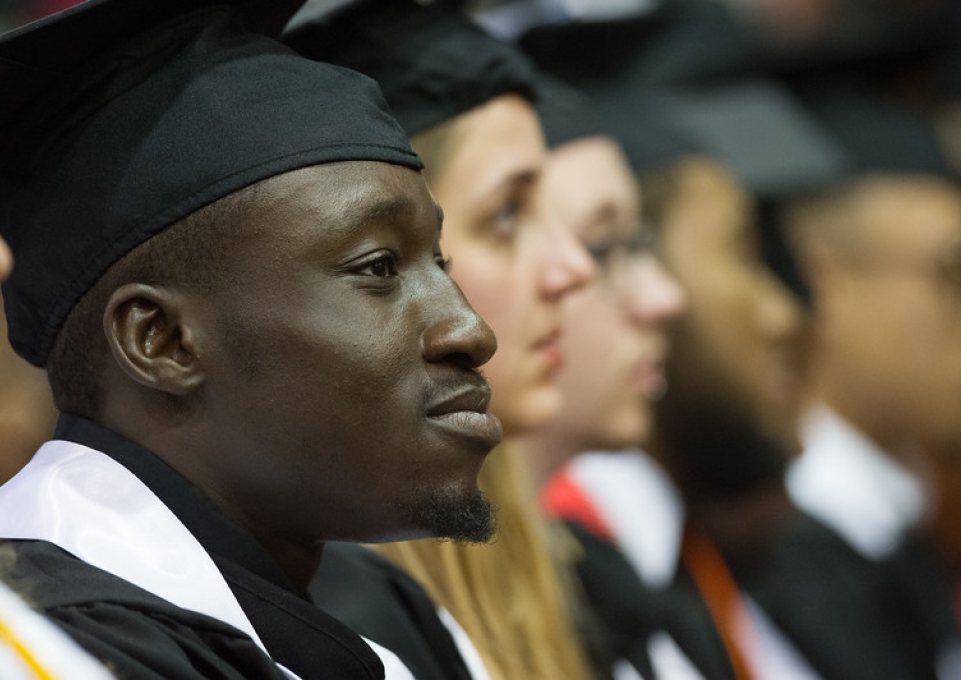 Student in commencement gear sitting and listening