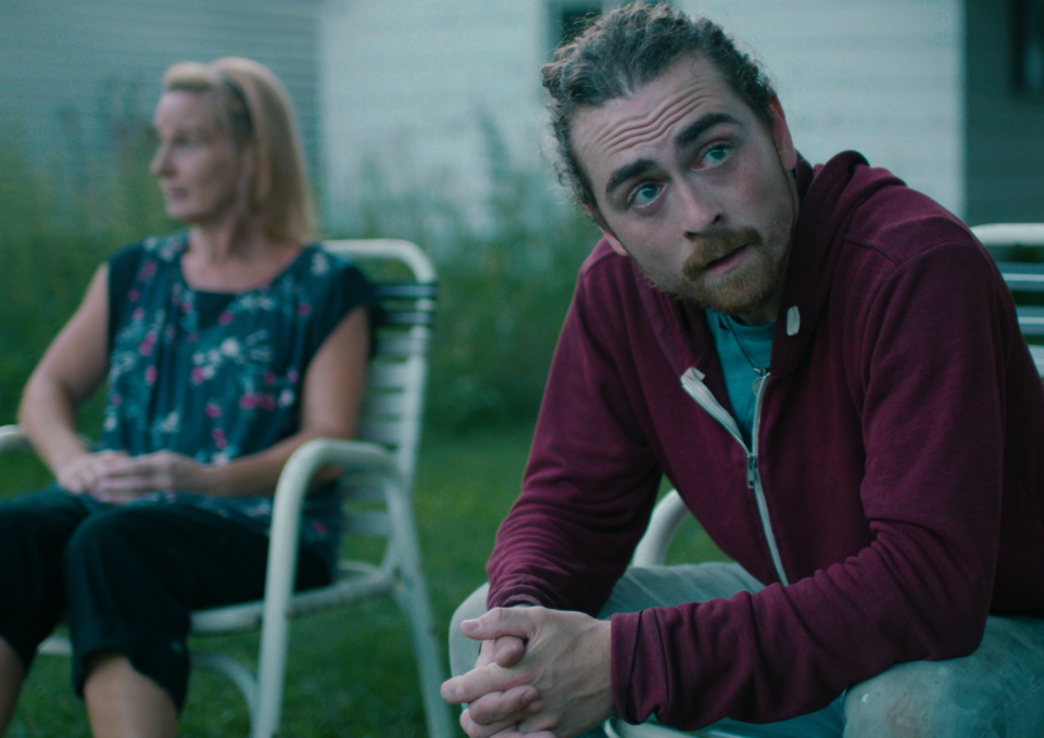 Actor Michael Charles Wagner seated in a chair, in a still from the film