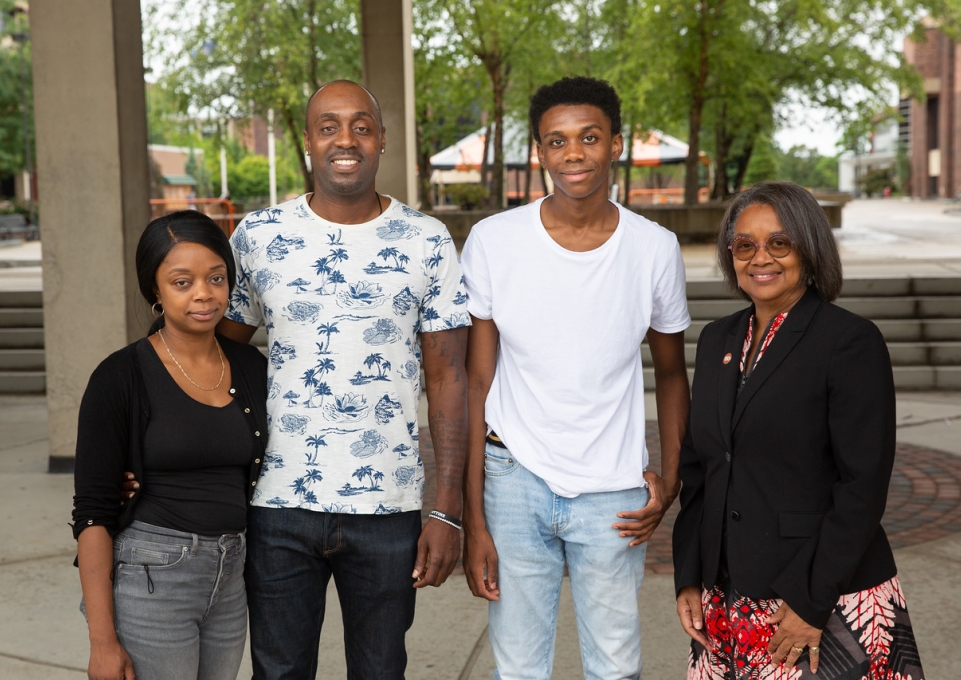 Jeremiah Simon standing with  his parents and President Katherine Conway-Turner