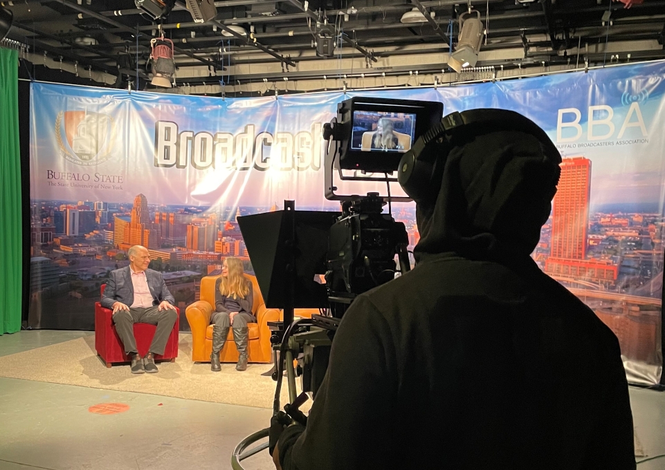 Student behind the camera filming an episode