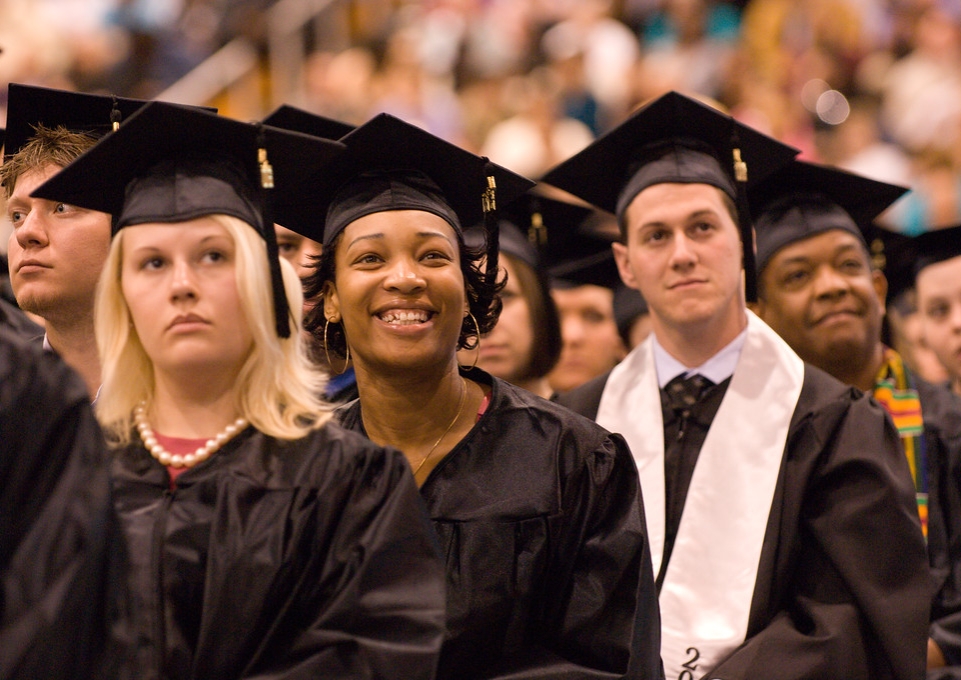 Smiling students seated at Commencement ceremony