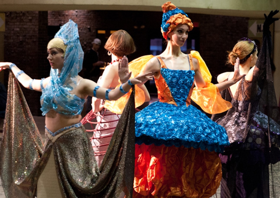 Actors arranged in a circle wearing colorful hoop dresses for the performance Alternative Dimensions