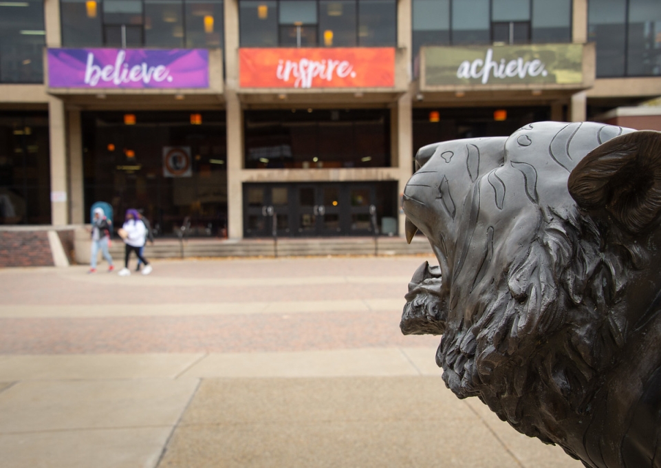 View of the Student Union sporting Believe, Inspire, Achieve banners with Bengal statue head in the foreground