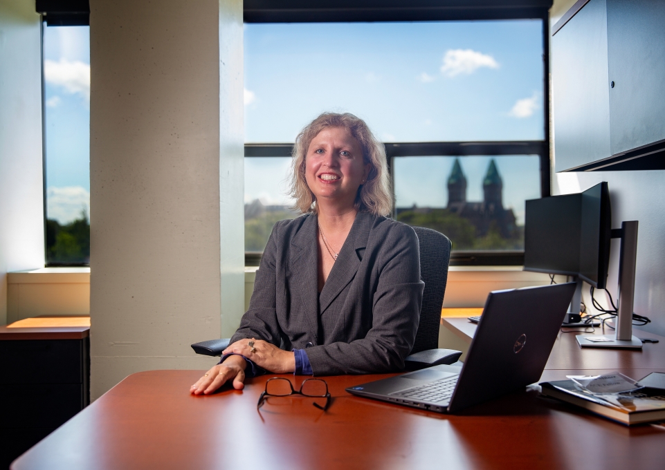 Andrea Milner seated at her desk with an open laptop