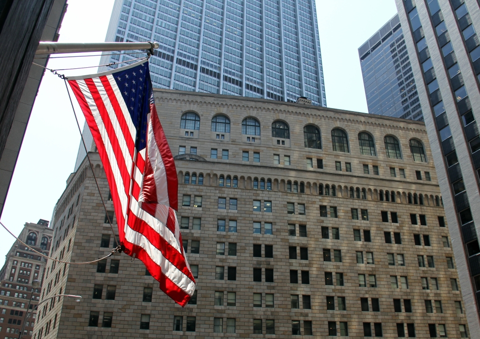 US Flag flying on the background of the facade of the Federal Reserve building in New York