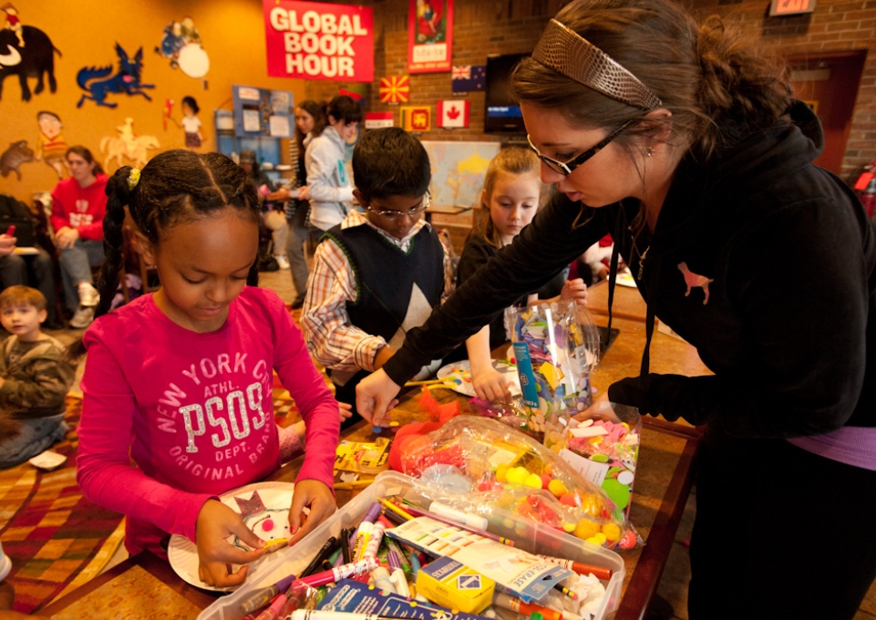 Children work on crafts with a teacher's help during Global Book Hour
