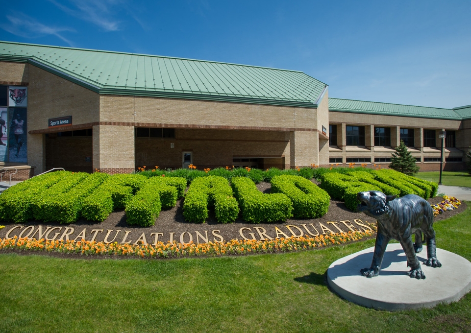 Shrubs outside the Sports Arena spell out Buffalo State with the words "Congratulations Graduates" underneath