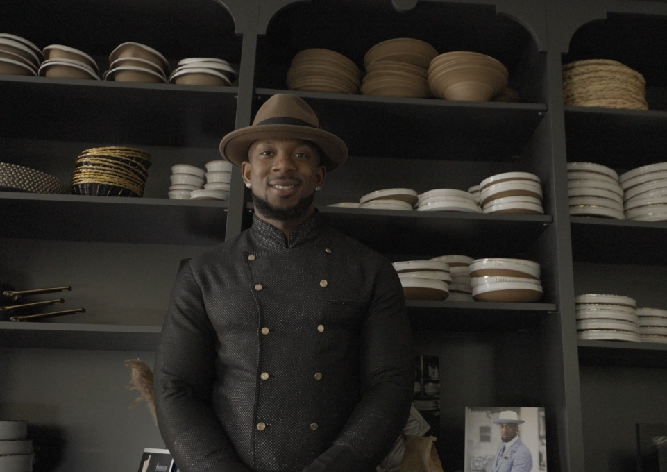 Darian Bryan stands in front of shelves of dishes