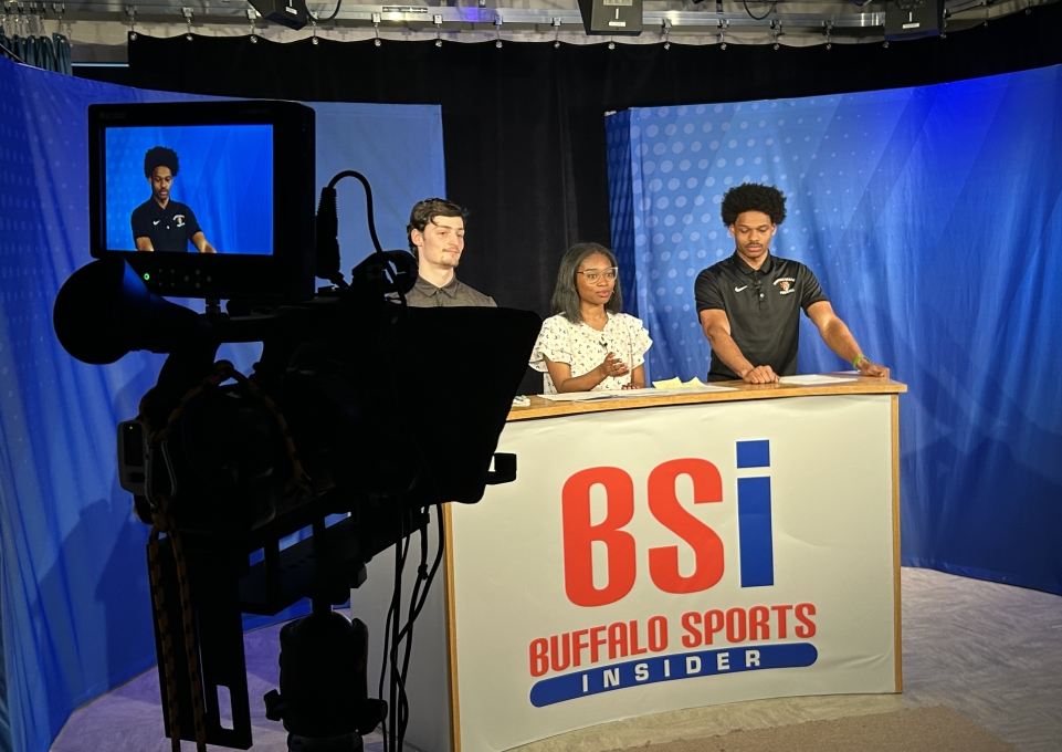 Behind the scenes image of camera filming students broadcasting sports news at Buffalo Sports Insider