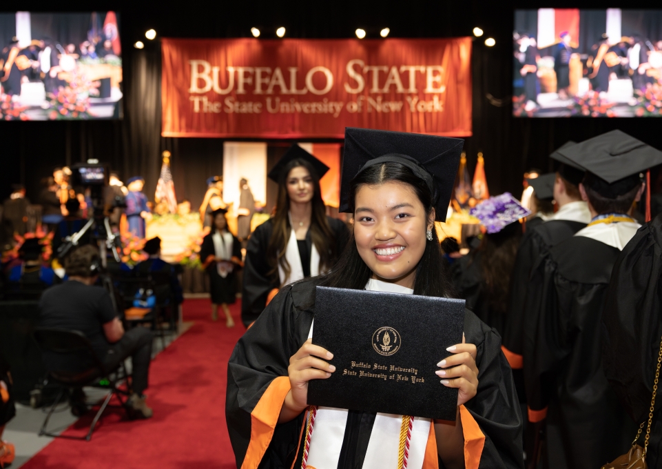 A Buffalo State graduate holds her diploma