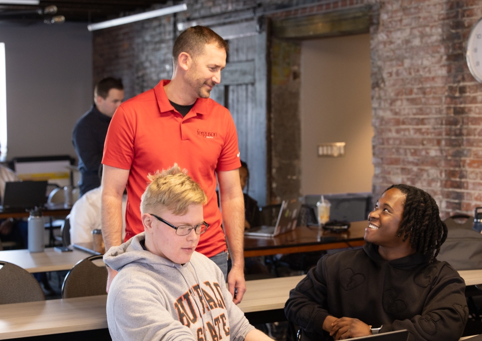 Paul Perry talking to two Buffalo State students